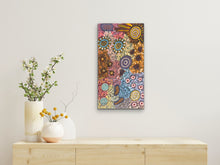 Load image into Gallery viewer, Indigenous dot painting on a wall above a wooden console table with decorative vases.