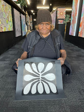 Load image into Gallery viewer, Debra Nangala McDonald holding Mulga painting in gallery