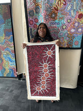 Load image into Gallery viewer, Artist holding her Seven Sisters Dreaming Aboriginal artwork in gallery
