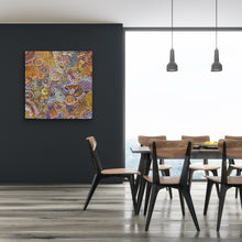Load image into Gallery viewer, Dining room with a colourful painting "My Country (Utopia)" Janet Golder Kngwarreye 94cm x 91cm on a black wall and a wooden dining table