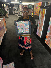Load image into Gallery viewer, Photo of Rhoda Tjitayi presenting her Piltati Tjukurpa painting inside Art by Farquhar Aboriginal Art Gallery, Edwardstown.