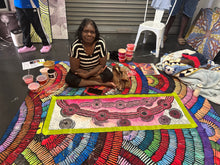 Load image into Gallery viewer, Photograph of the artist standing beside her artwork showing scale and vivid desert tones