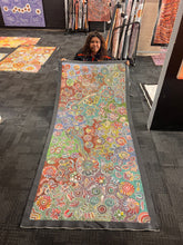 Load image into Gallery viewer, Bernadine Johnson Kemarre holding her vivid floral dot painting at Art by Farquhar Aboriginal Art Gallery.
