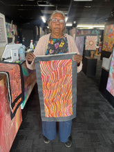 Load image into Gallery viewer, Maureen Hudson holding painting in gallery
