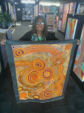 Load image into Gallery viewer, Audrey Brumby holding her painting Places and Waterholes in gallery
