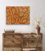 Load image into Gallery viewer, Wooden dresser with a wicker chair, woven basket, and vase with flowers against a white wall with sand dune art.
