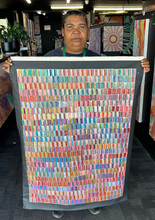 Load image into Gallery viewer, Bernadine holding a colourul painting in an art gallery setting
