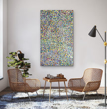 Load image into Gallery viewer, Modern living room with wicker chairs, a colorful  Bessie Pitjara 161cm x 94cm Bush Plum Colourful Aboriginal Artwork, and a small table with decorative items.
