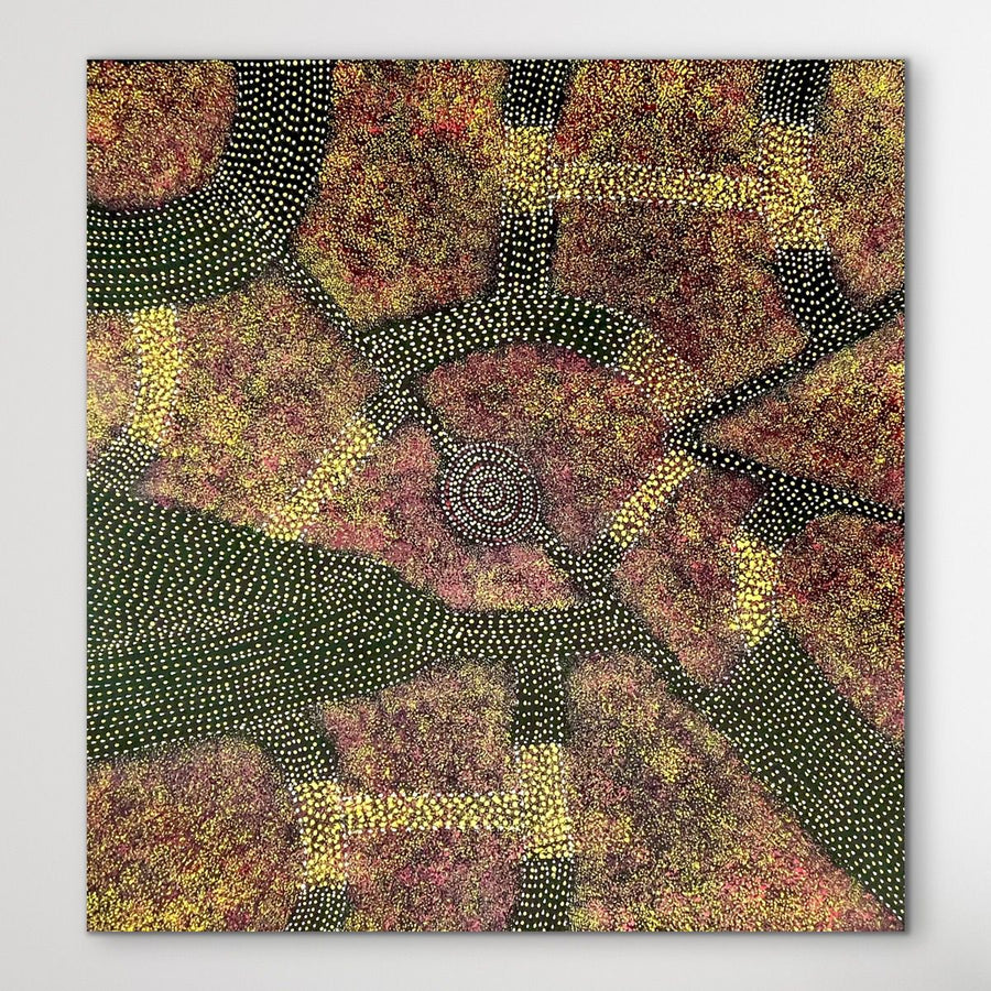Square Aboriginal Dot Painting with oranges, red and yellow by Roseanne Morton displayed on a white wall