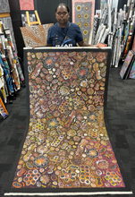 Load image into Gallery viewer,  Rochelle Bird Mbitjana holding painting &quot;Bush Yam Dreaming&quot; 198cm x 110cm
