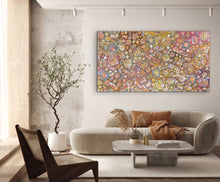 Load image into Gallery viewer, Modern living room with a colorful &quot;Bush Yam Dreaming&quot; Rochelle Bird Mbitjana 198cm x 110cm Aboriginal Painting on wall, a sofa with decorative pillows, and a coffee table.
