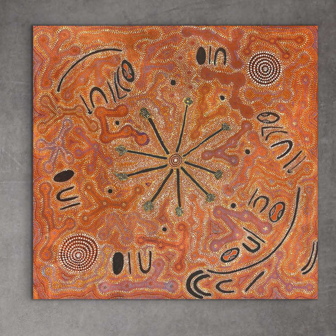 A piece of Aboriginal artwork featuring a central bushfire design with surrounding patterns and text. 