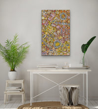 Load image into Gallery viewer, Indigenous painting on a wall above a white desk with plants and decor.
