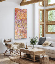 Load image into Gallery viewer, Living room with a colorful Inidgenous bush plum painting, rocking chair, and wooden coffee table.
