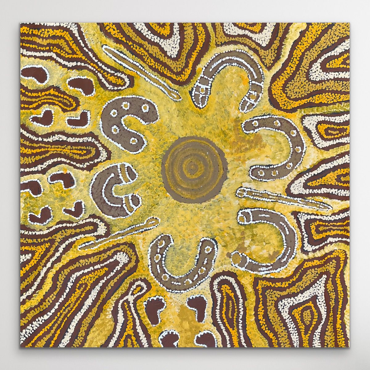 Indigenous piece with circular patterns in brown, yellow, and white on a gray background