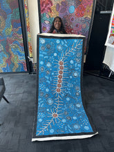 Load image into Gallery viewer, Artist holding her painting to show scale and vibrant colour of the Seven Sisters and Women Dancing Ceremony artwork.
