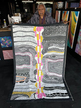 Load image into Gallery viewer, Artist Alice Granites Napanangka holding her large Mina Mina Dreaming painting, showing scale and colour vibrancy.
