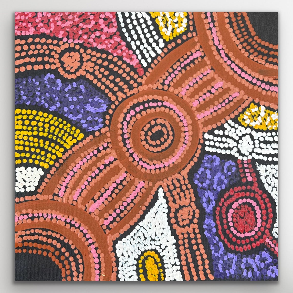 Close-up showing the central circular motif and vibrant dot work from Clarise Tunkin’s Minma Maliilu painting.