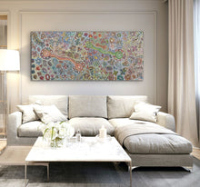 Load image into Gallery viewer, Modern living room with a large floral Aboriginal painting above a sectional sofa.
