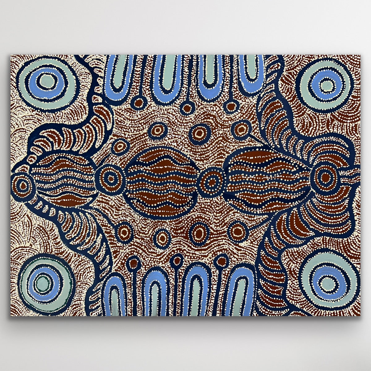 Rich blue rings and warm ochre patterns intertwine to form a mesmerising desert composition.