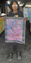 Load image into Gallery viewer, Aboriginal artist Rhoda Tjitayi holding her painting Piltati Tjukurpa
