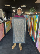 Load image into Gallery viewer, Marshall Jangala Robertson holding his Seed Dreaming Aboriginal artwork, 90cm x 36cm, authentic Indigenous painting with artist pictured.
