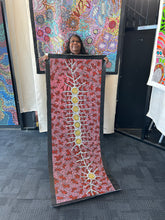 Load image into Gallery viewer, Aboriginal artist Michelle Possum Nungurrayi holding her Seven Sisters Dreaming artwork
