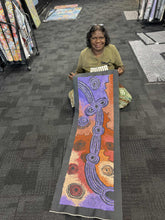 Load image into Gallery viewer, Photo of Teresa Baker holding her Minyma Maililu painting at Art by Farquhar Aboriginal Art Gallery in Edwardstown.

