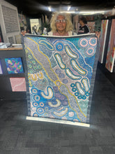 Load image into Gallery viewer, The artist Teresa Punami Mula Pimangka photographed holding her large painting Seven Sisters at Art by Farquhar Aboriginal Art Gallery.
