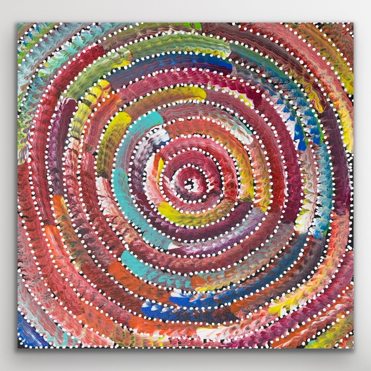 Full view of the circular Aboriginal painting Circle of Life featuring rhythmic red, yellow, and blue dot patterns symbolising harmony and connection.