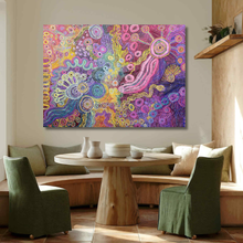 Load image into Gallery viewer, Colorful Indigenous painting on a wall above a wooden table with green chairs in a room.
