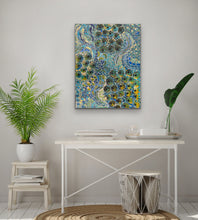 Load image into Gallery viewer, Aboriginal painting on a wall above a desk with plants and decor.
