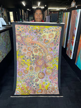 Load image into Gallery viewer, Bernadine Johnson Kemarre holding a colorful abstract artwork in an art gallery setting
