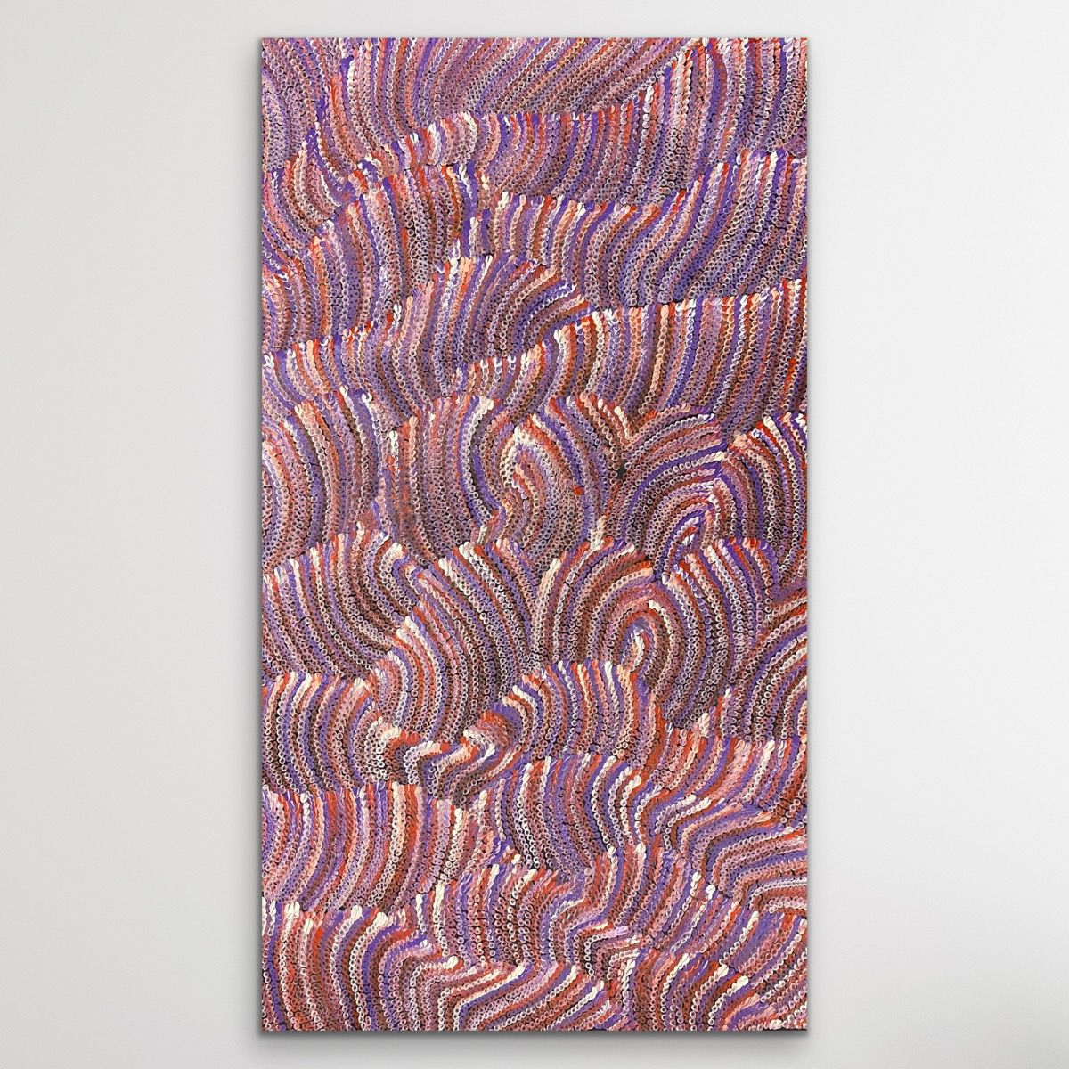 dot painting with wavy pattern in purple, orange, and pink displayed on wall