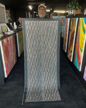 Load image into Gallery viewer, Aboriginal Seed Dreaming dot painting by Marshall Jangala Robertson 180cm x 70cm, artist holding canvas with cultural story design.
